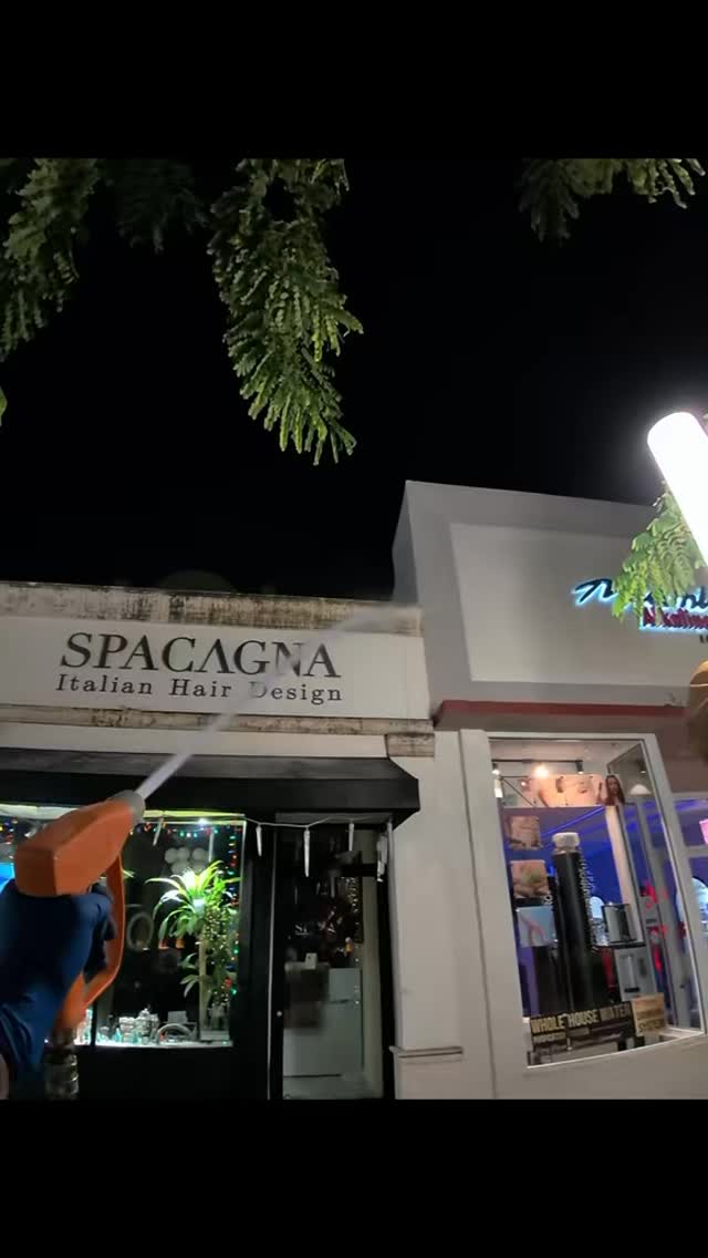 Commercial storefront pressure washing in action at night — TitanFlow Exteriors